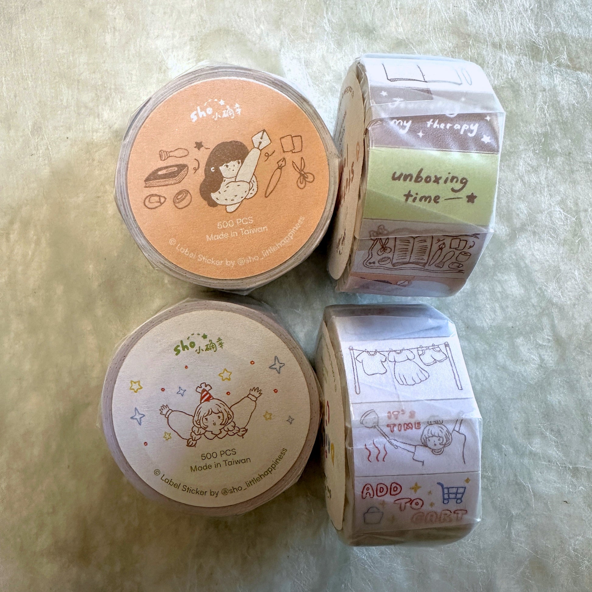 Four rolls of decorative tape with cartoon designs on a textured surface